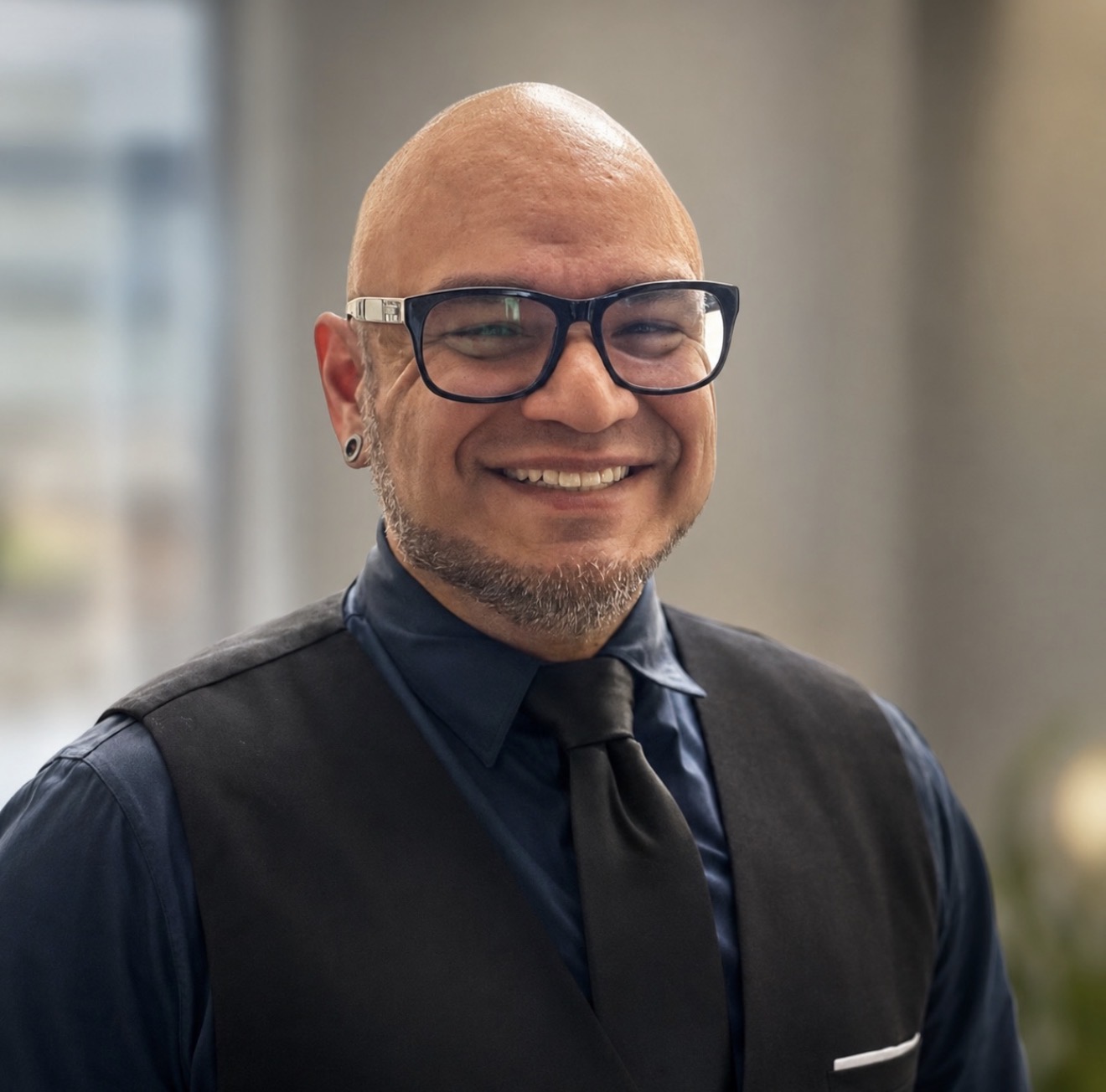Luis Zilla Rodriguez, owner of Zilla IT Consulting, smiling in glasses and a dark vest
